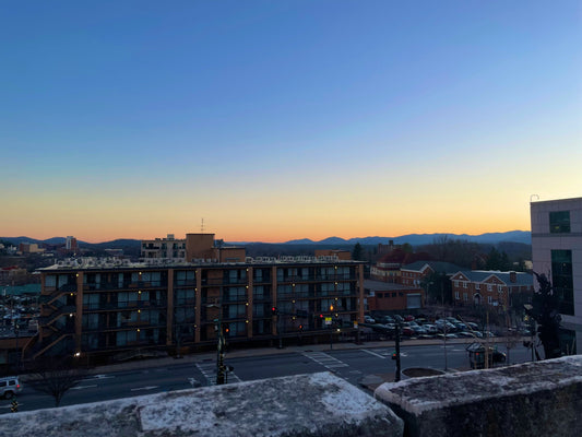 View of Asheville cityscape with mountains in the background, representing commercial lighting in North Carolina and Charlotte