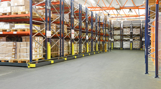 Warehouse with outdated HID high bay lighting and storage racks, ideal for LED retrofit by NCLTG