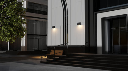 Two full cutoff LED wall pack lights mounted on the side of a modern building, providing bright illumination to an outdoor area with a wooden bench.